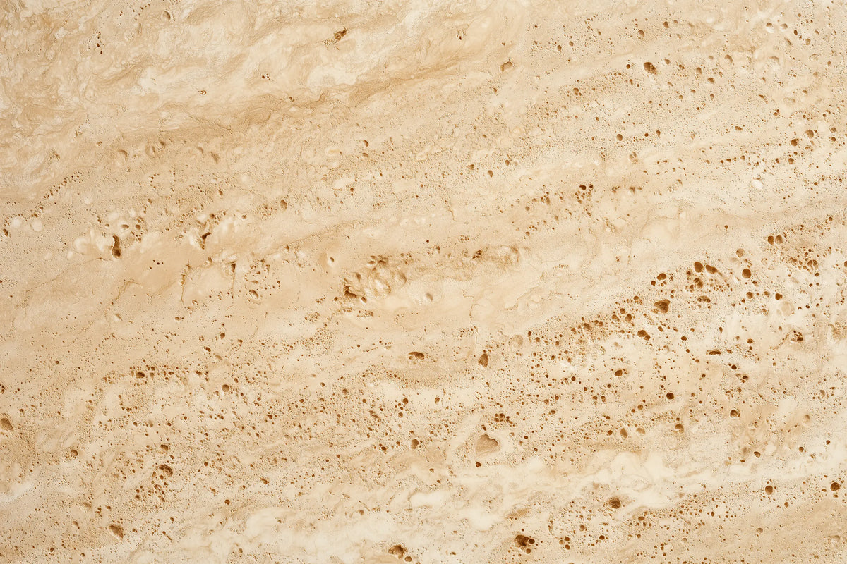 Beige travertine stone texture with natural brown veining and porous mottling throughout.
