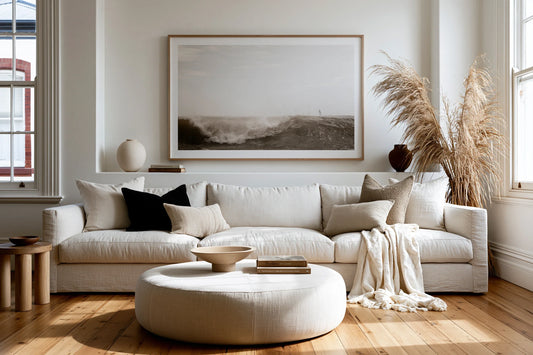 Large framed wall art hung above a linen sofa in a modern Australian living room with timber floors and natural light