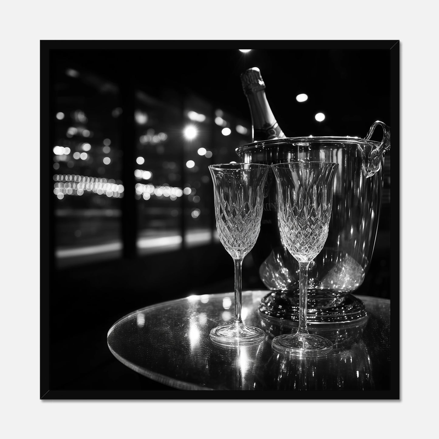 Black framed print of two wine glasses and a bottle of champagne in an ice bucket on a reflective surface with a night-time cityscape background.