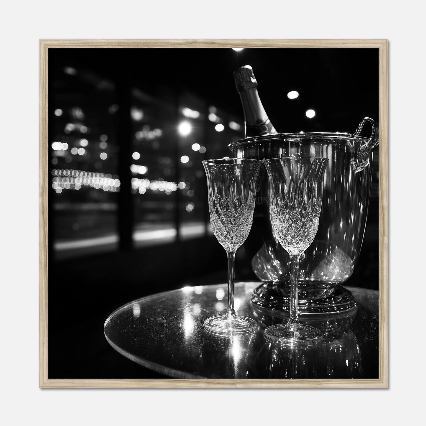Natural oak framed print of two wine glasses and a bottle of champagne in an ice bucket on a reflective surface with a night-time cityscape background.