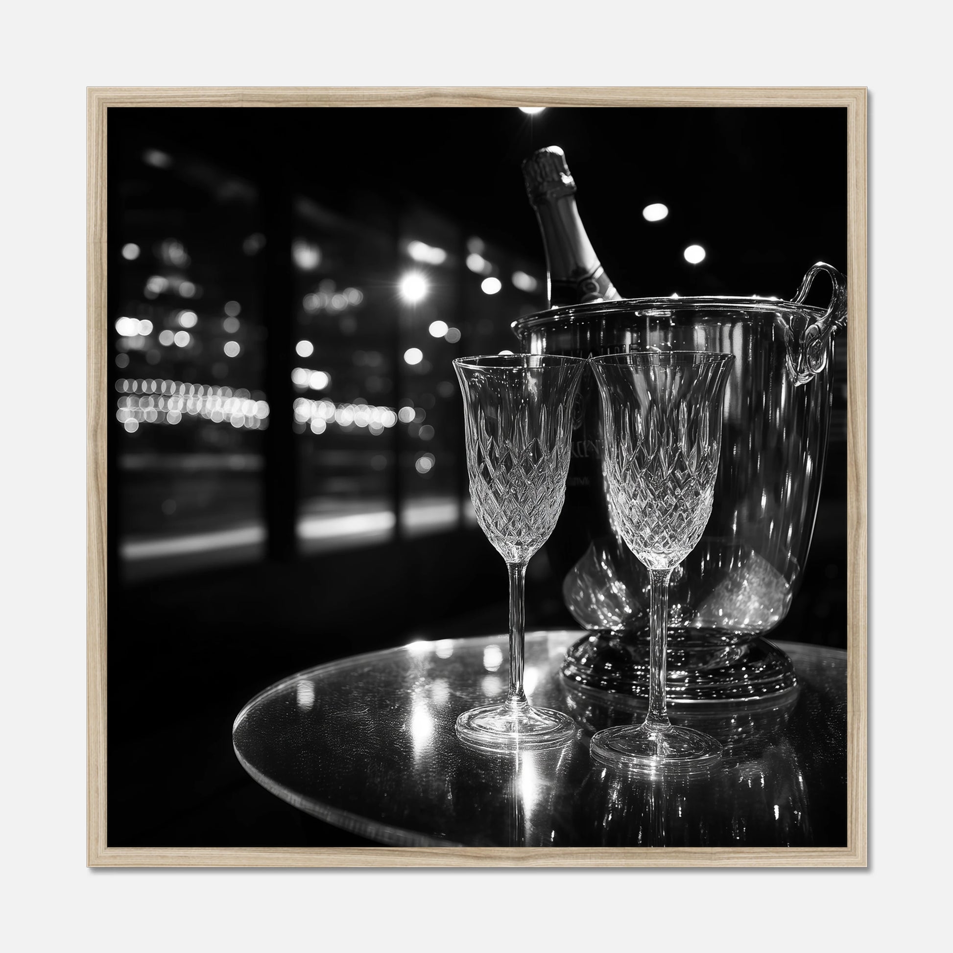Natural oak framed print of two wine glasses and a bottle of champagne in an ice bucket on a reflective surface with a night-time cityscape background.