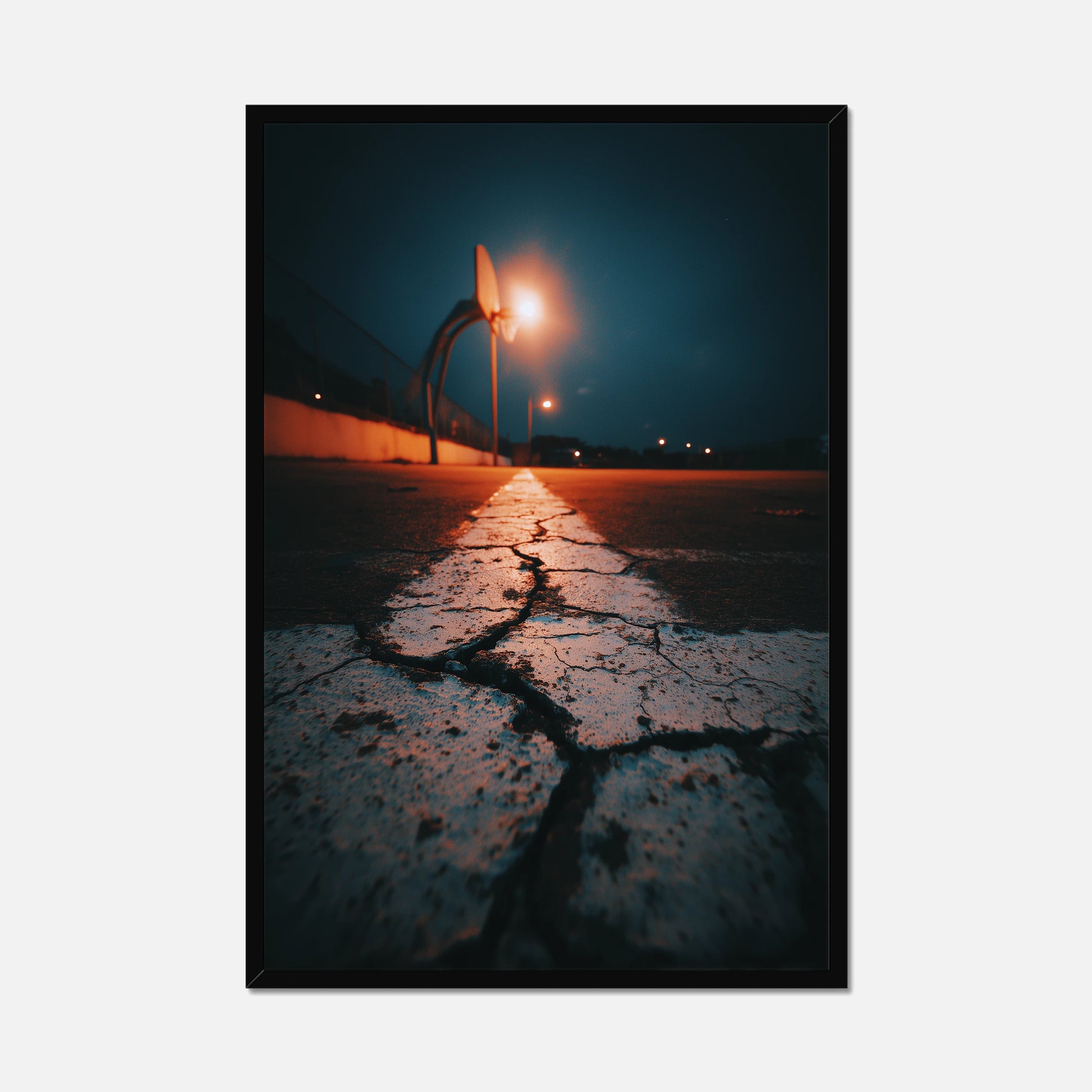 Framed artwork of a street scene with a light post and cracked pavement at night.