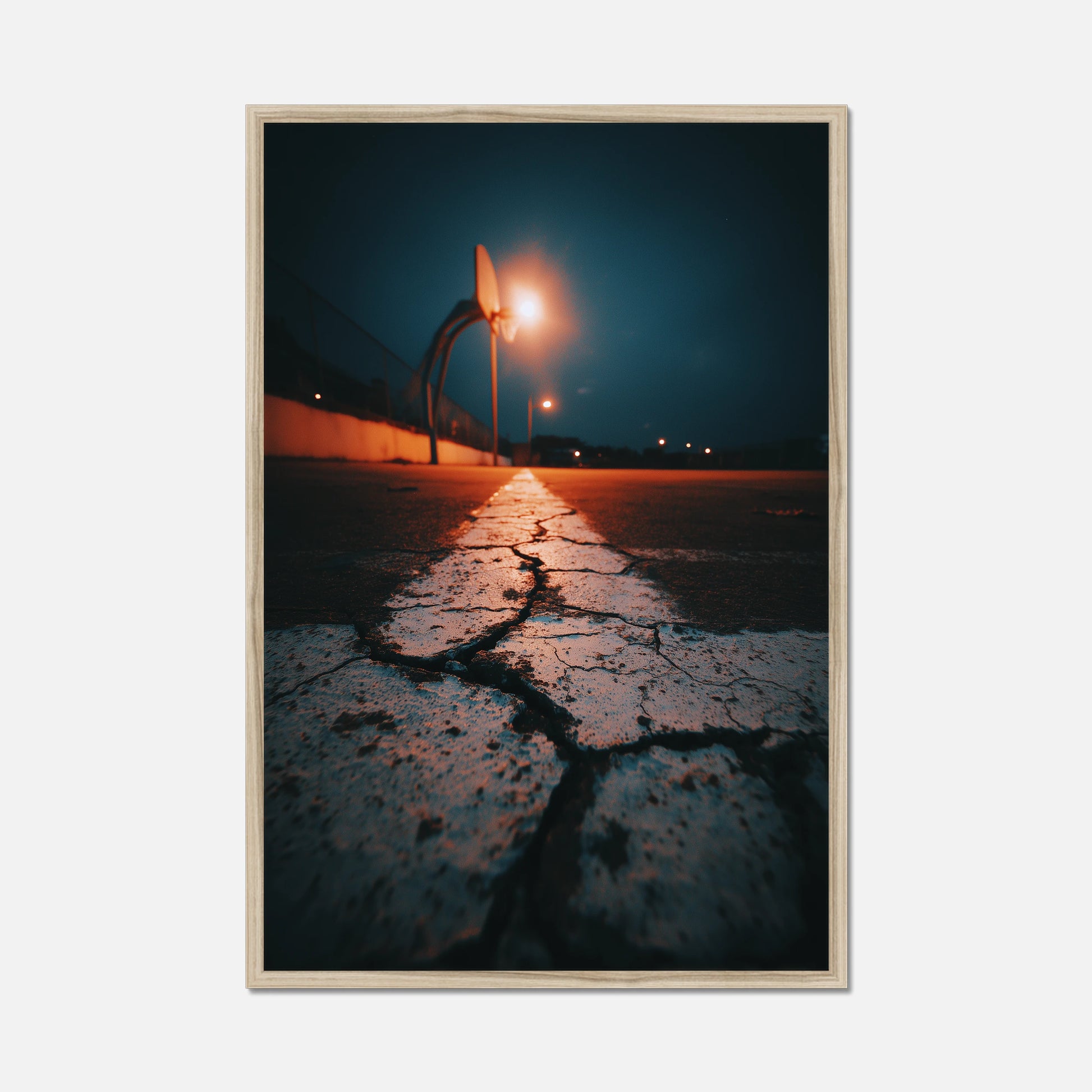 Framed photograph of a street scene with a light post and wet pavement at night.