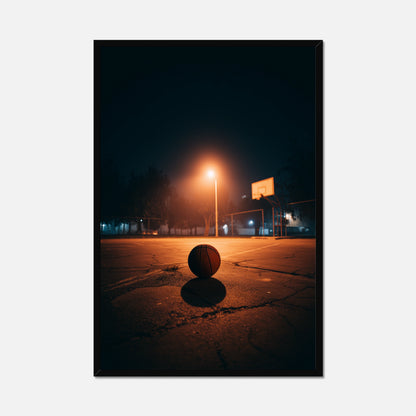 Basketball on a court at night with a single light illuminating the scene