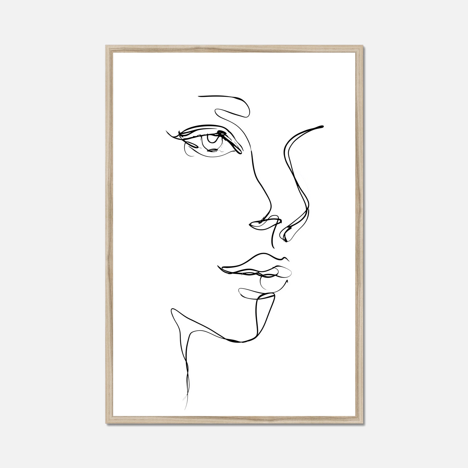 A minimalist black and white line art print of a woman's face in profile, presented in a thin natural oak frame against a light gray background.