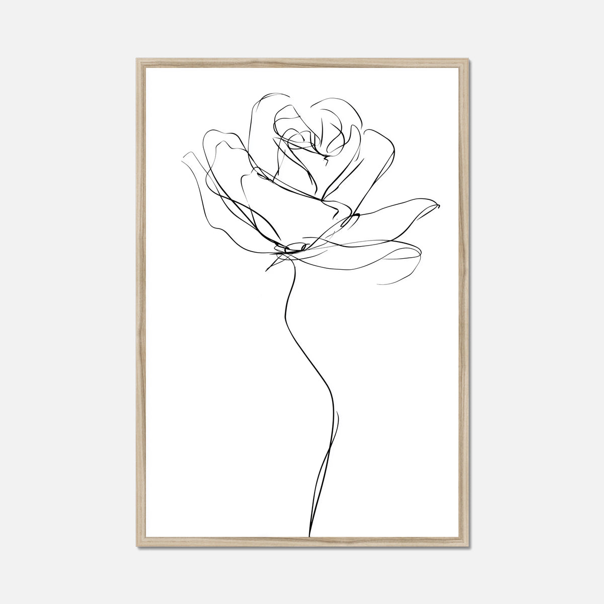 A minimalist black line art print of a rose on a white background, framed in a light natural wood frame, shown against a light gray wall.