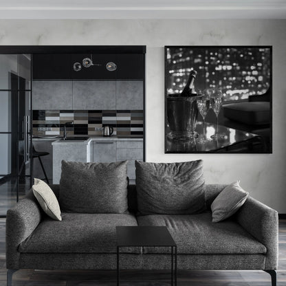 Modern living room with a gray sofa, kitchen in the background, and a decorative wall piece.