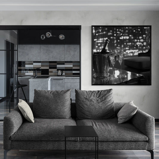 Modern living room with a gray sofa, kitchen in the background, and a decorative wall piece.