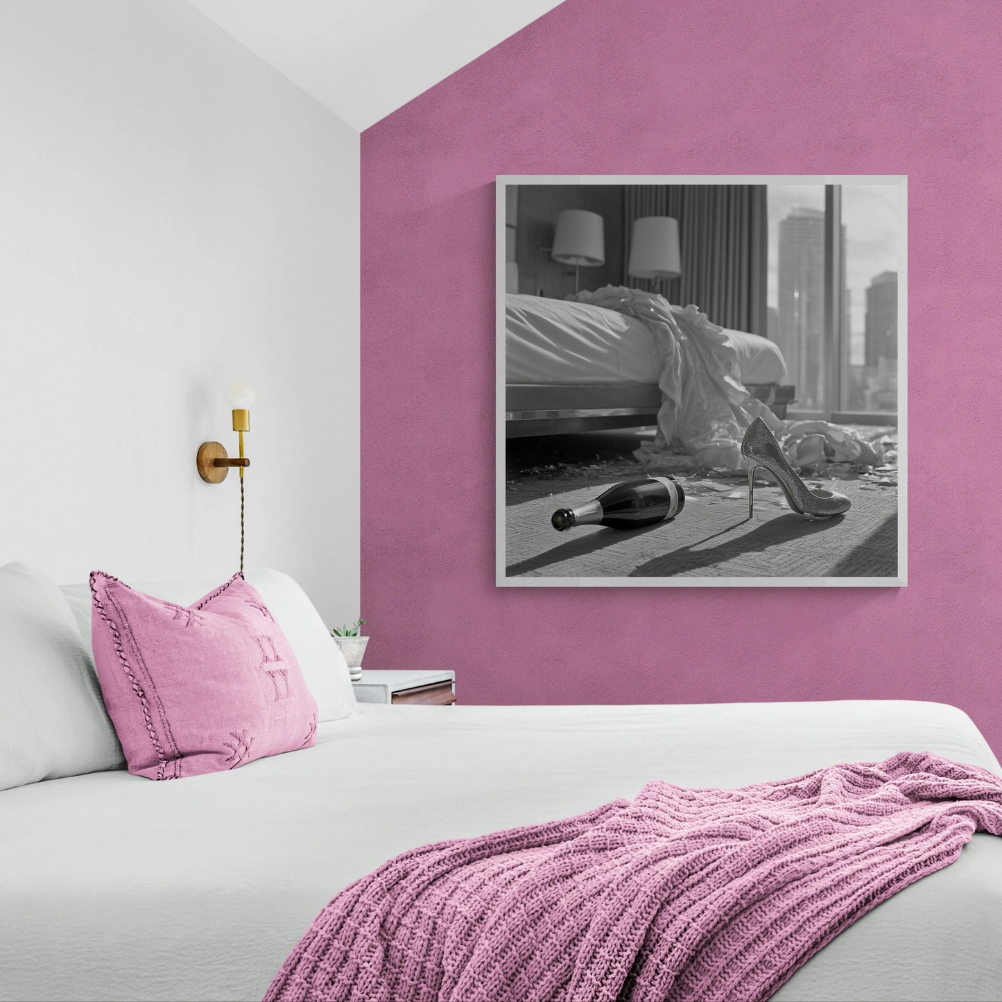 Modern bedroom with pink walls, pink blanket, and pink pillow on a bed, featuring a framed black and white wall art statement piece on the wall.