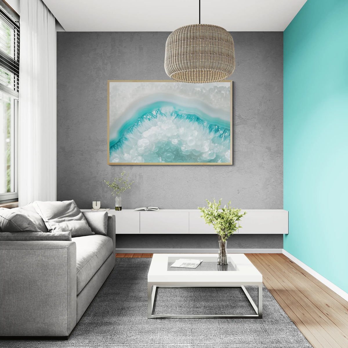 A modern living room featuring the best framed abstract wave art print with turquoise and white tones hanging on a textured gray wall above a white media console and gray sofa.