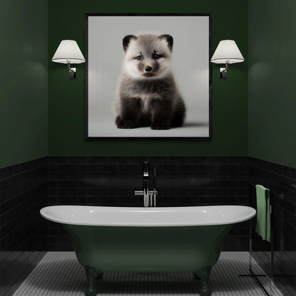 A framed black and white portrait print of an arctic fox hanging on a dark green wall above a vintage-style bathtub in a modern bathroom setting.