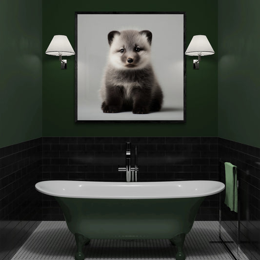 A framed black and white portrait print of an arctic fox hanging on a dark green wall above a vintage-style bathtub in a modern bathroom setting.