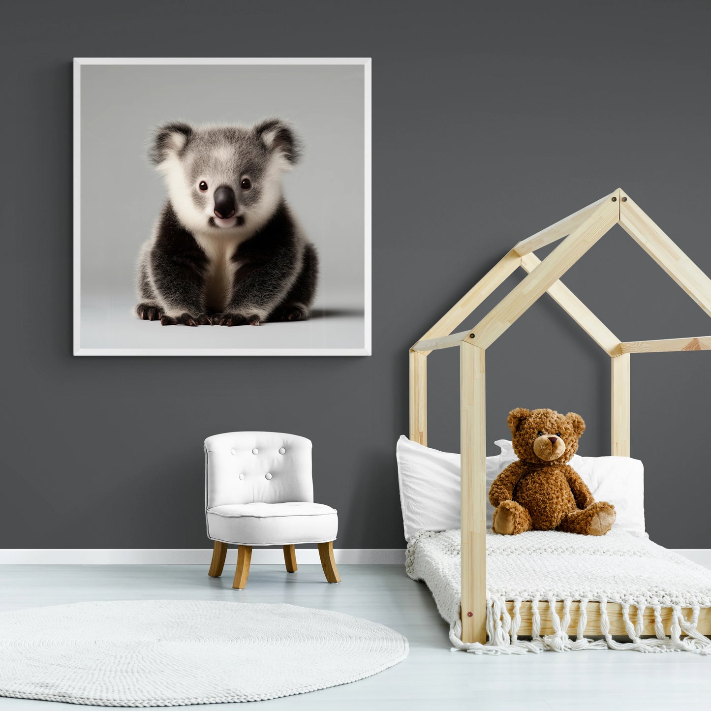 Children's room with a framed picture of a koala, a teddy bear on a bed, and a small white chair.