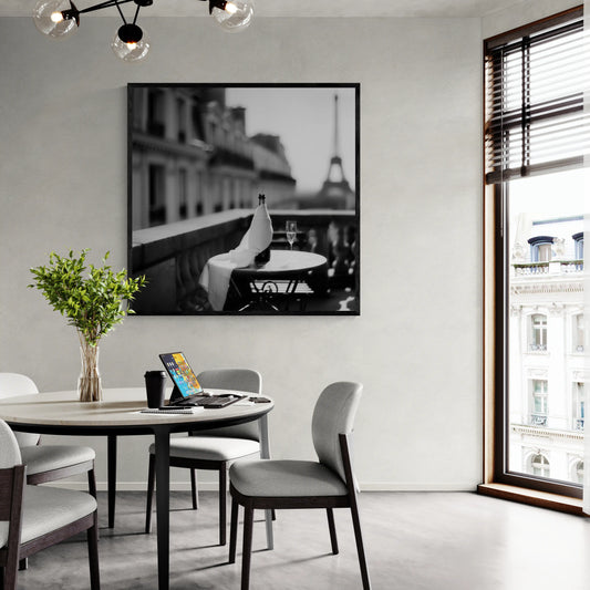 Modern dining room with a round table, chairs, and a large window with a beautiful wall art piece.