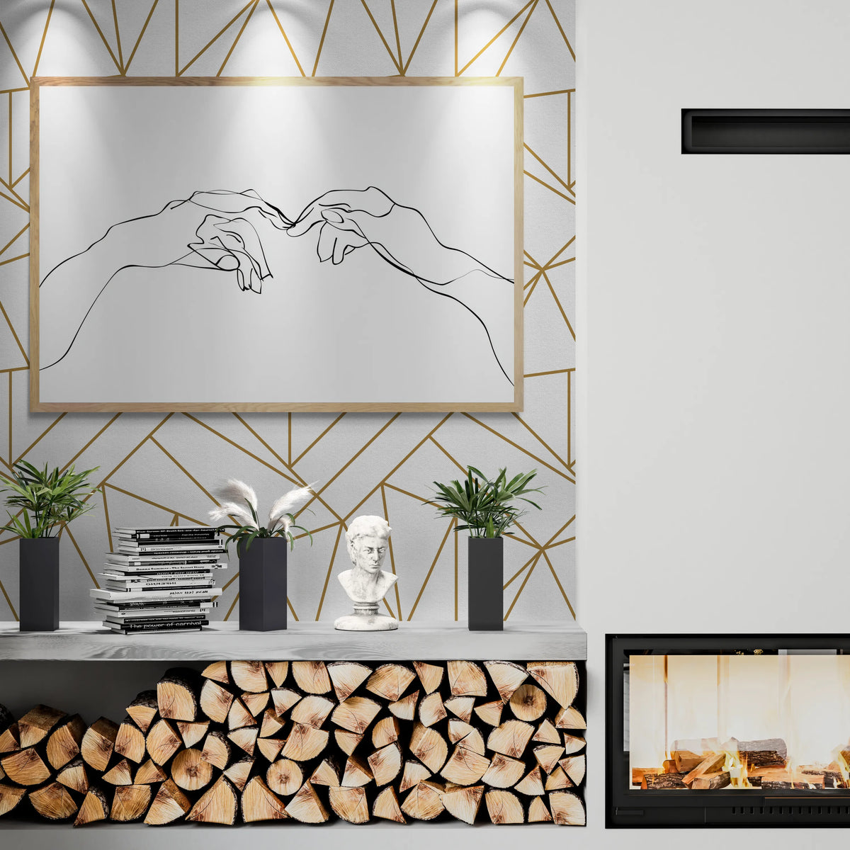 The best modern living room interior featuring a large framed minimalist line art print of two hands reaching for each other, hung on a geometric gold and white wall above a console shelf with stacked books, plants, a small bust sculpture, and a wood-burning fireplace.