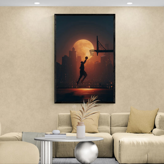 A large vertical framed wall art print showing a basketball player silhouette jumping toward a hoop in front of a glowing orange moon and city skyline, displayed above a beige sofa in a modern living room.