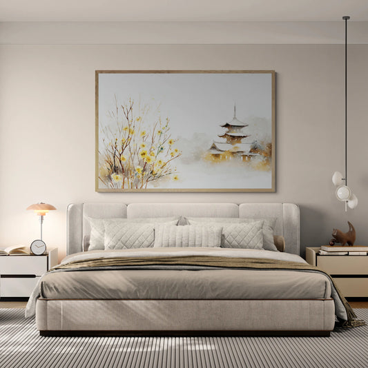 A modern bedroom featuring a large framed wall art print depicting a Japanese pagoda and yellow blossoms, hung above a beige upholstered bed.